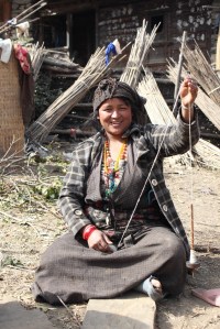 A Tamang woman making yarn in her front yard.